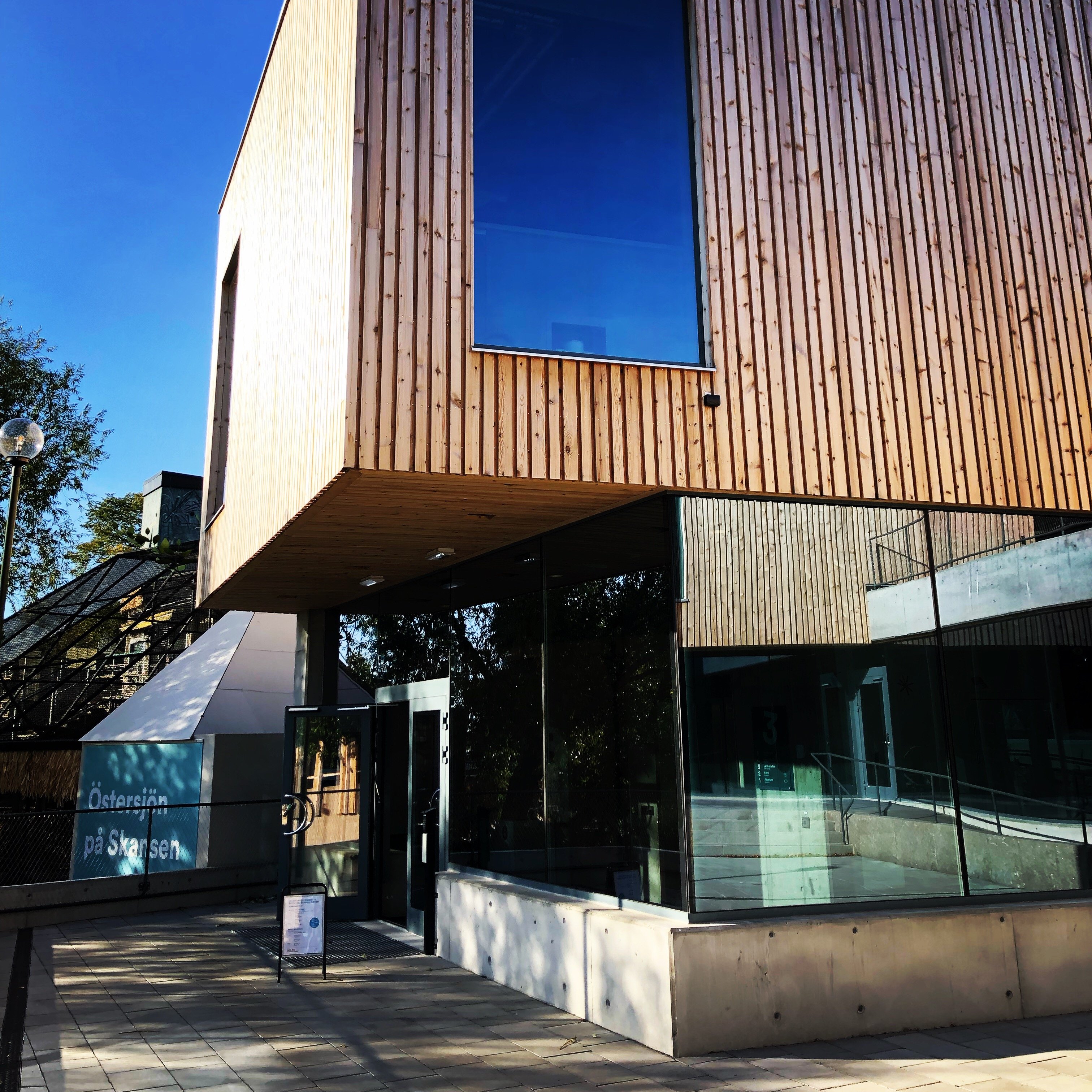 A building with wooden panneling and a concrete base.