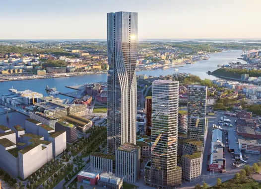 Tall glass buildings tower over a modern city bordering a nearby harbour